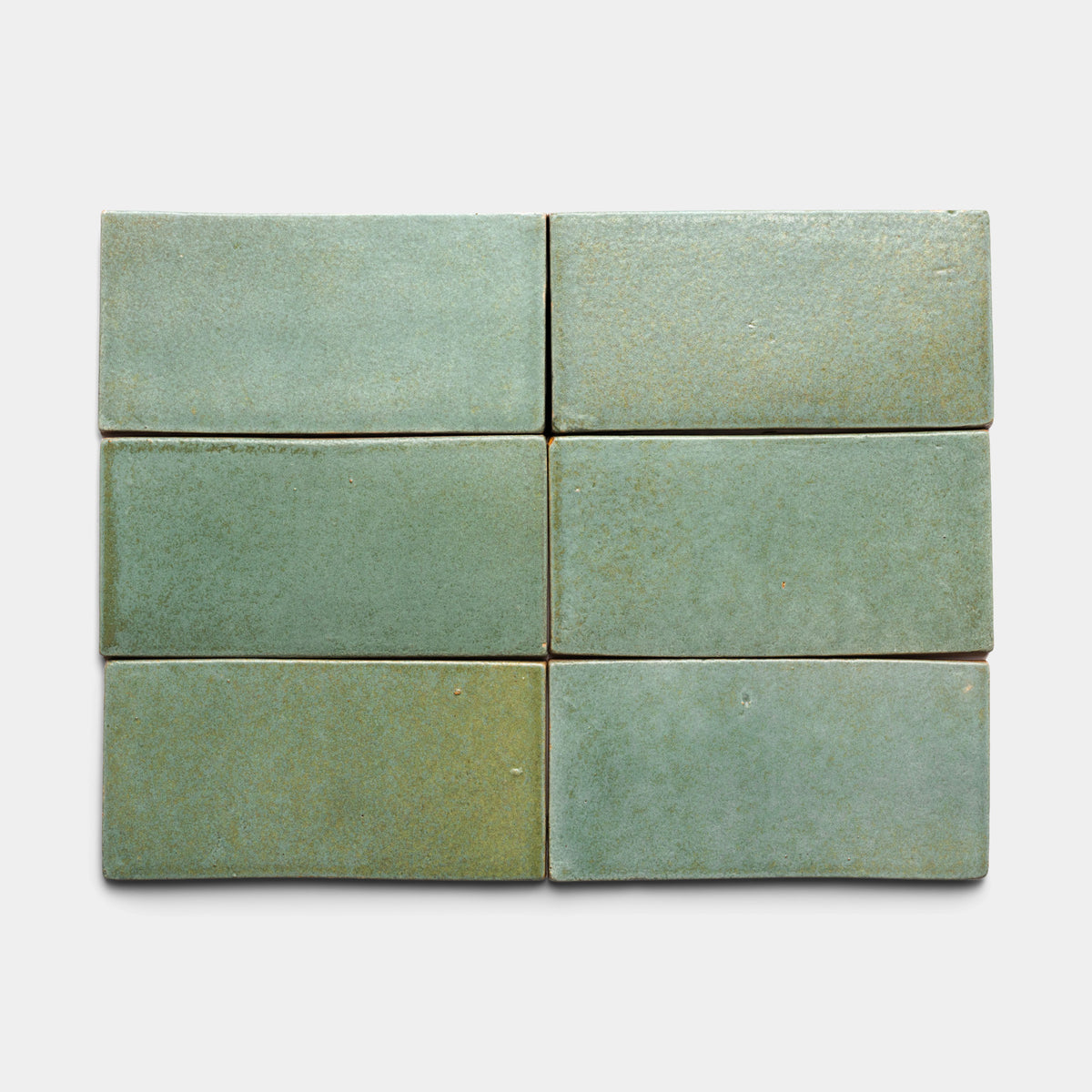 Six Peyote 4x8 Rectangle tiles by Zia Tile, in sage green ceramic with a matte finish, are arranged in two rows of three against a plain, light background.