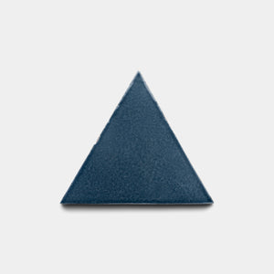 The Zia Tile Piedra Triangle features a solid dark blue equilateral triangle set against a plain white background.