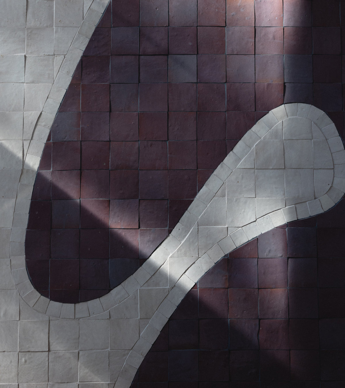 A pattern of Plum 4x4 zellige tiles and off-white squares arranged in a curved design.
