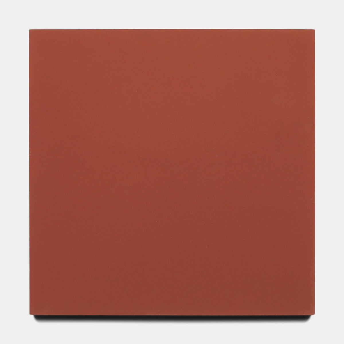 The Zia Tile Pompeii 8x8 Sample is a plain, solid reddish-brown square tile photographed on a white background, bringing classic warmth to any space.