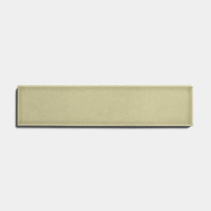 The Ponderosa 2x8 by Zia Tile is a rectangular ceramic tile in a light olive green glossy finish, centered on a plain white background to highlight its sleek, architectural grade look.
