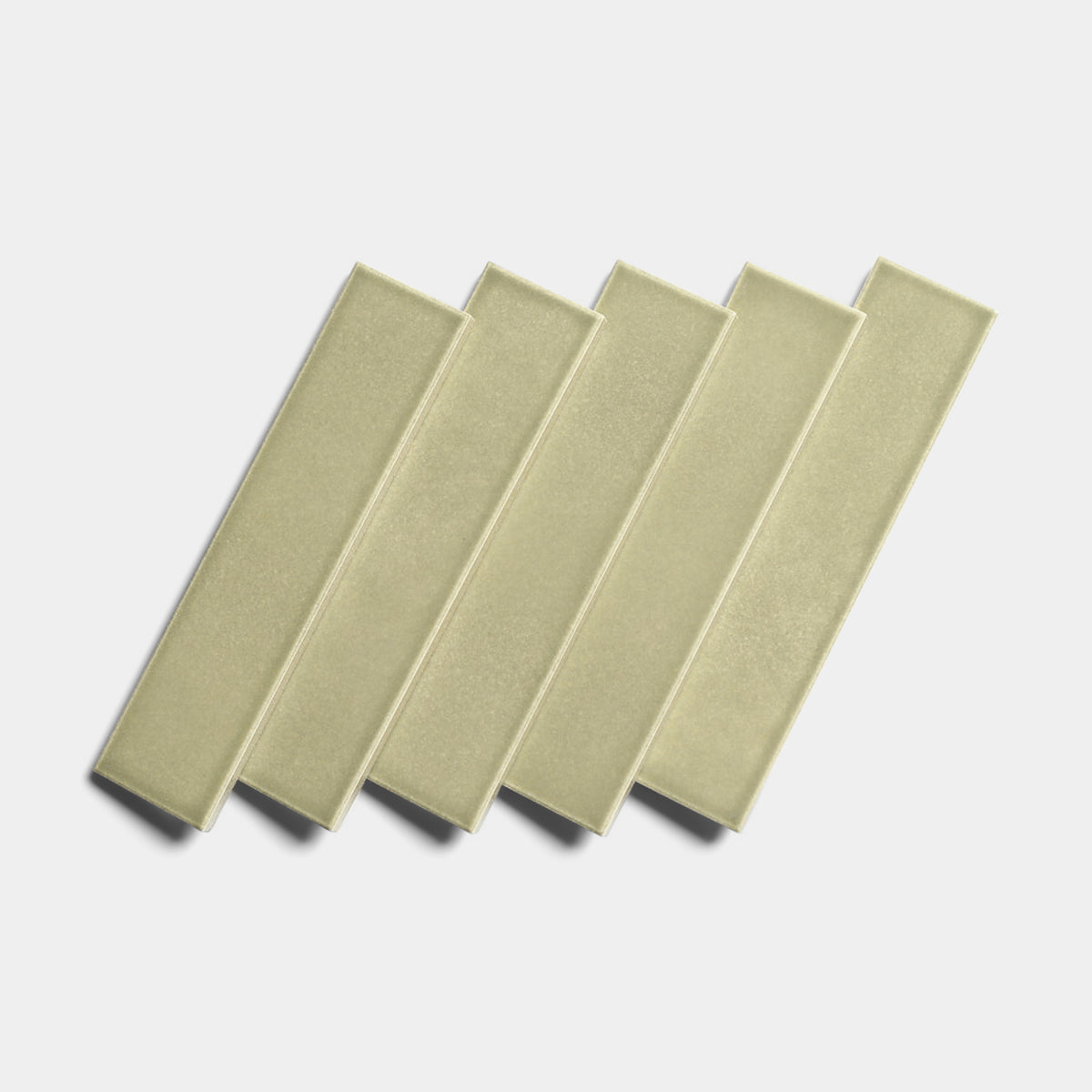 Five Ponderosa 2x8 architectural grade ceramic tiles by Zia Tile, in light olive-green, are arranged diagonally in a neat, overlapping row on a white background.