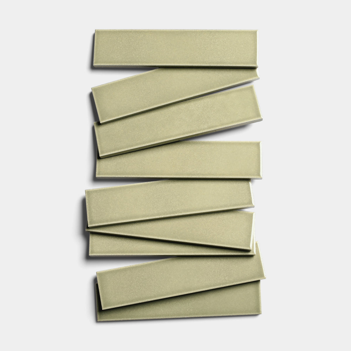 Eight Ponderosa 2x8 sage-green glossy ceramic tiles by Zia Tile are stacked in a staggered zigzag pattern on a white background.