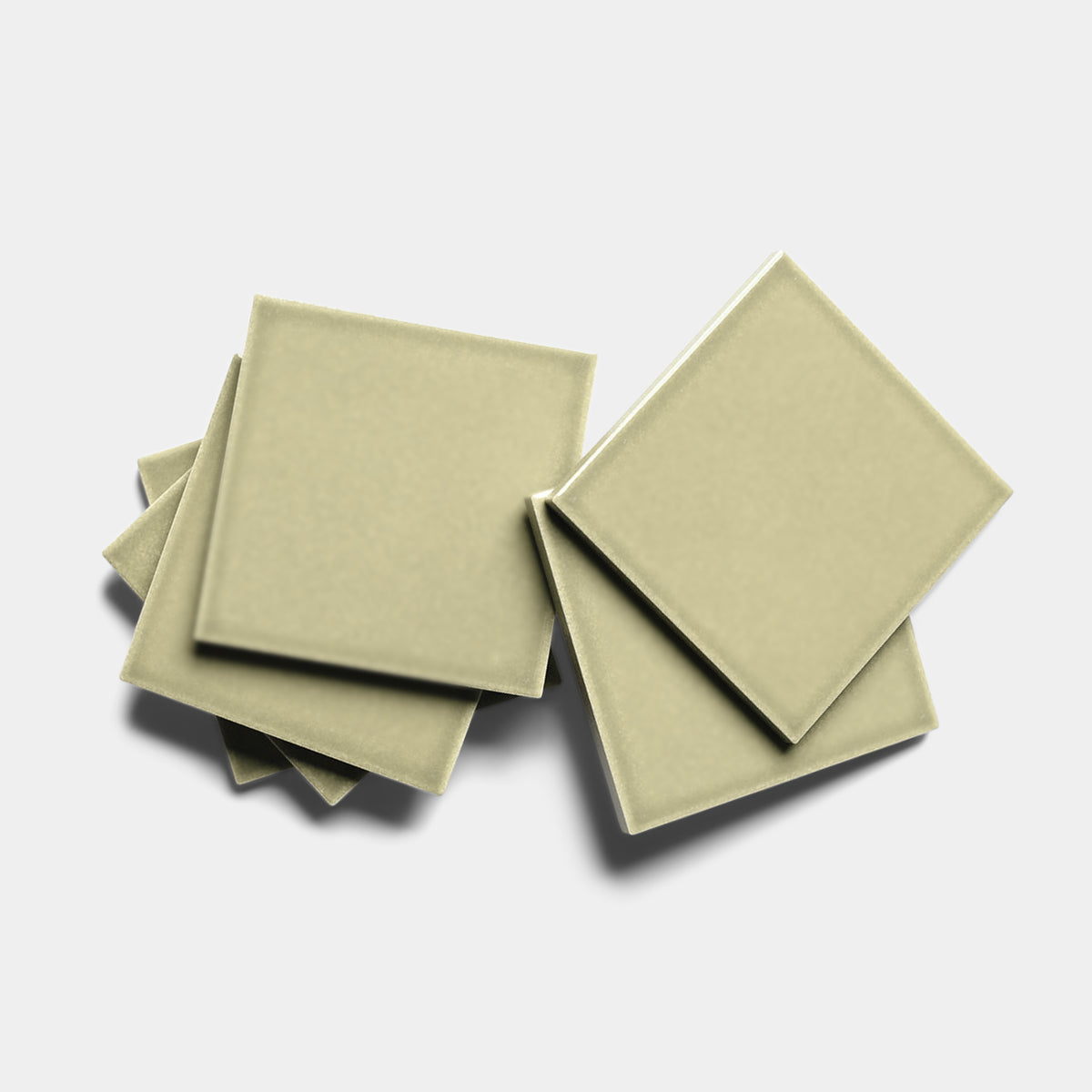 Six Ponderosa 4x4 square ceramic tiles by Zia Tile in light olive-green, arranged in a slightly overlapping, scattered pattern on a white background.