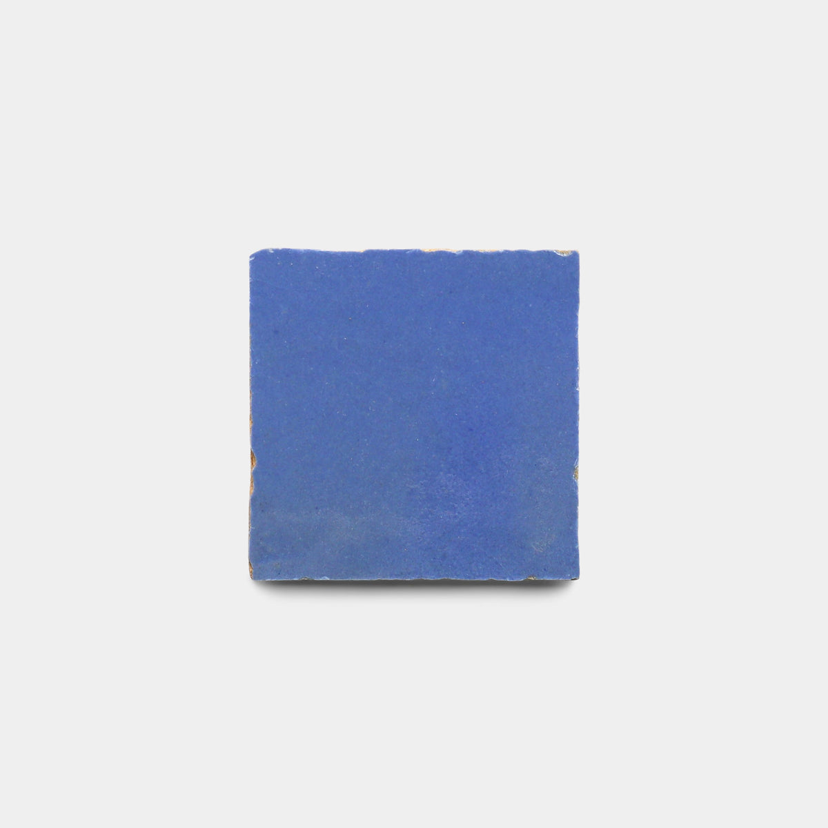 A single, square Portuguese Blue 2x2 ceramic tile sample by Zia Tile with a matte finish and slightly rough edges is centered on a plain white background.