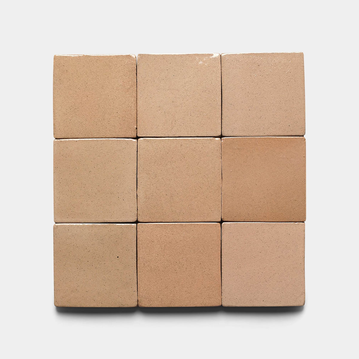 Nine Posada 4x4 Square tiles by Zia Tile are displayed in a 3x3 grid on a white background, featuring a beige, matte finish with subtle shade variations that highlight their handmade artisanal appeal.