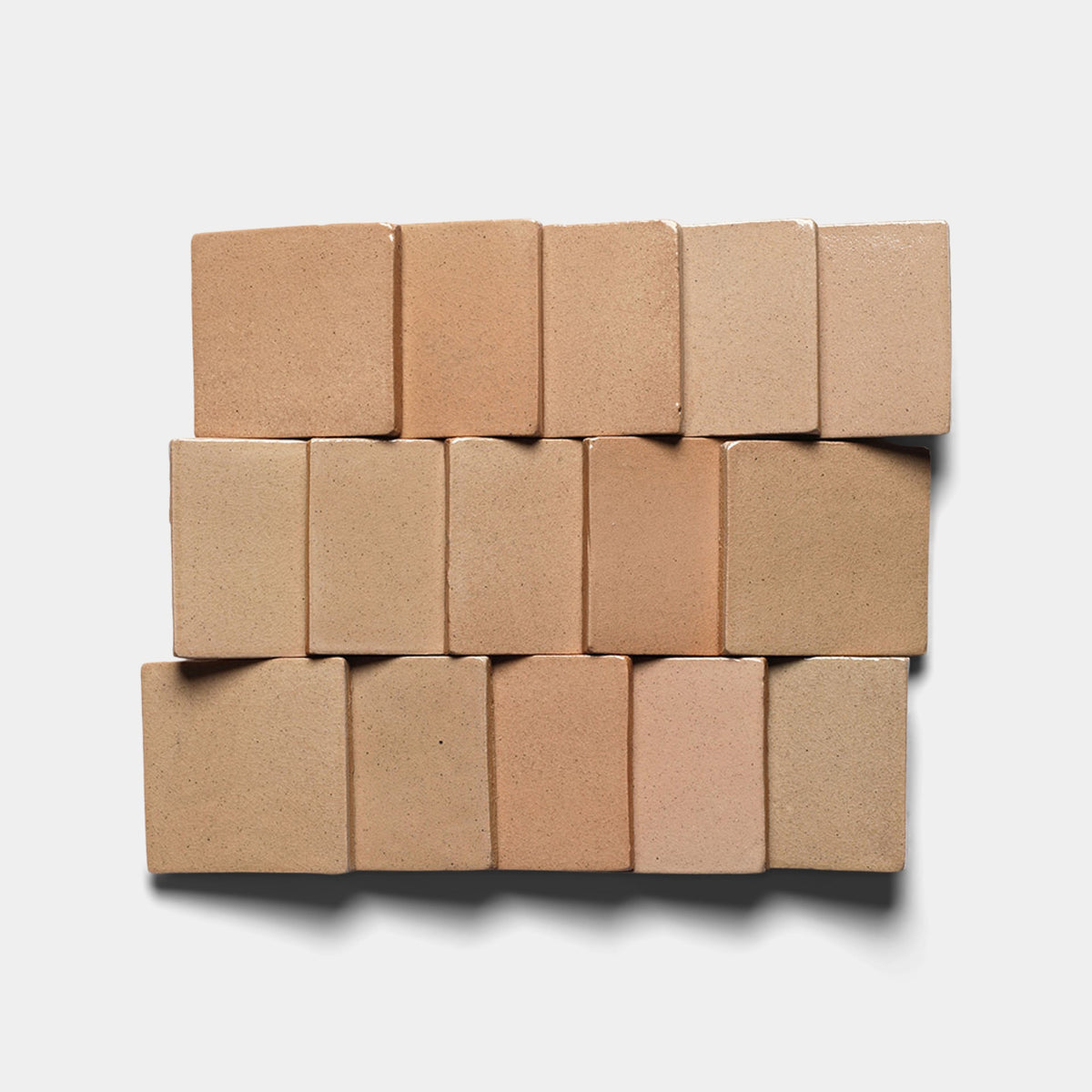 Fifteen Zia Tile Posada 4x4 Square samples in soft, varying neutral tones are arranged in three rows on a white background. Each handmade tile casts subtle shadows to the lower right.