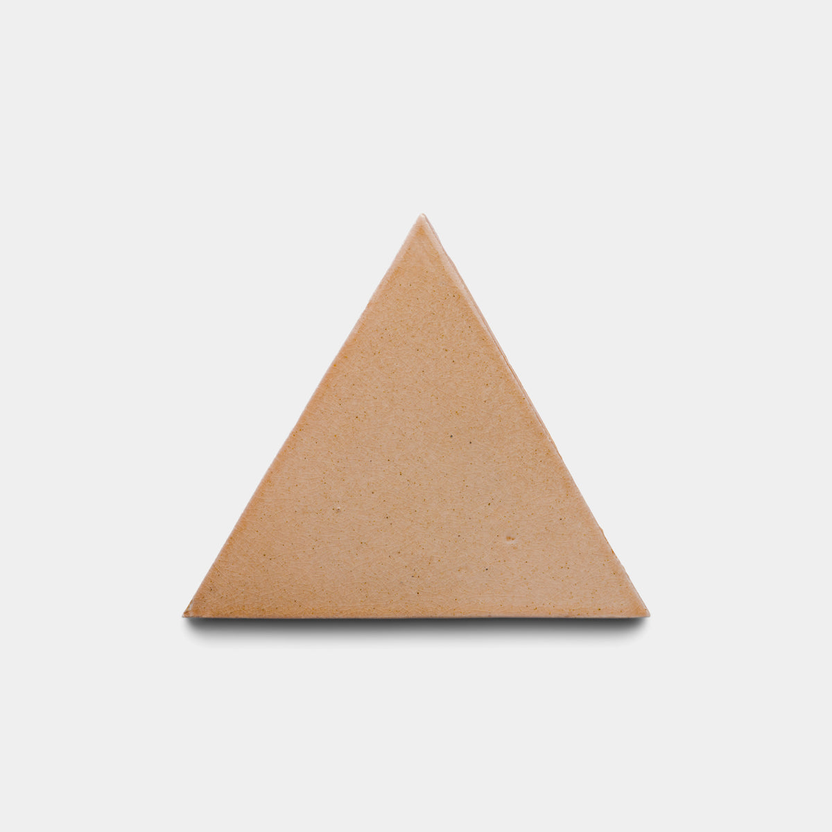 The Posada Triangle by Zia Tile, a solid light brown, triangle-shaped tile, is centered on a plain white background.