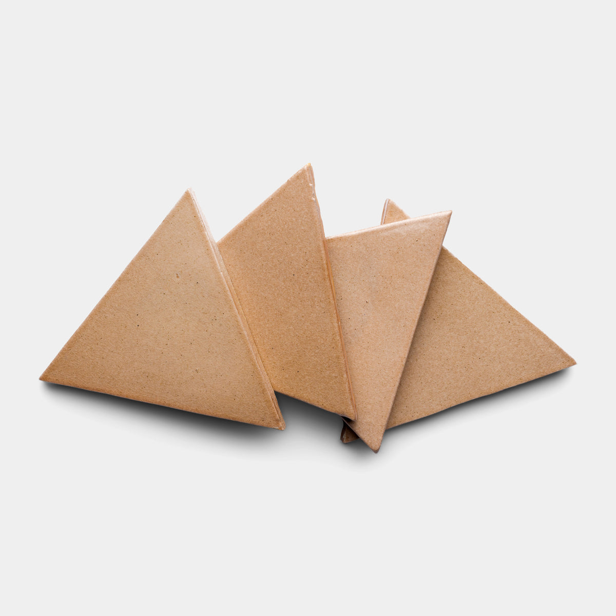 Four brown Posada Triangle tiles by Zia Tile are arranged overlapping each other on a plain white background.