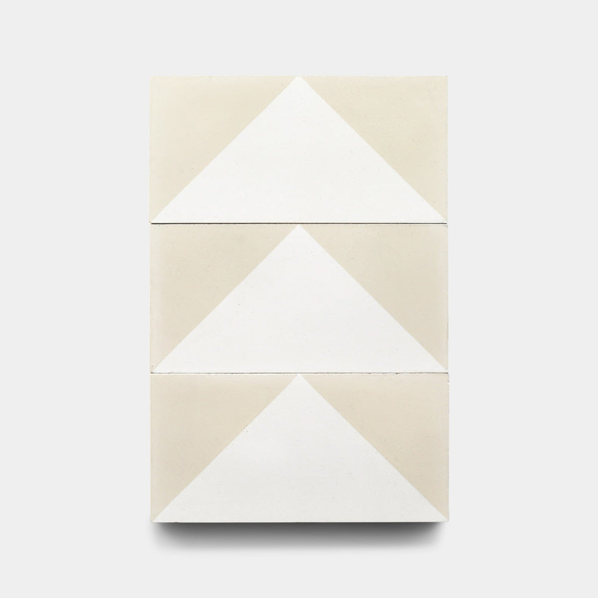 Three Press Play Nile 4x8 samples from Zia Tile are stacked vertically, each displaying a white triangle pointing upward on a light beige background for a minimalist, geometric look.
