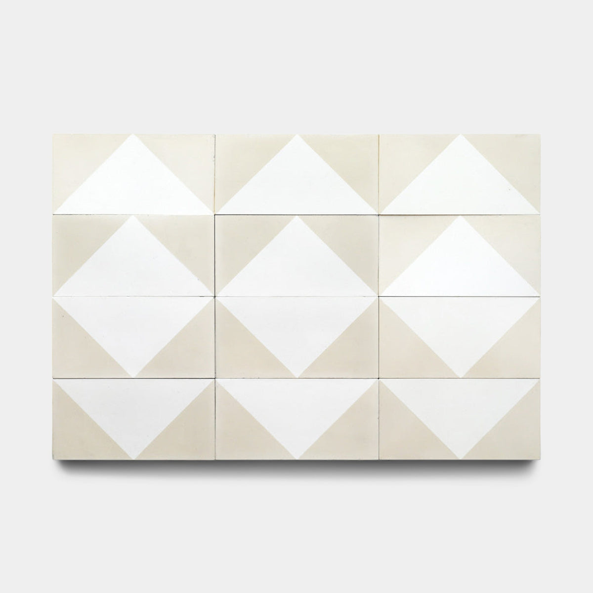 The Zia Tile Press Play Nile 4x8 Sample is a rectangular artwork of twelve handmade tiles in three rows and four columns, showcasing white and beige geometric patterns on a light gray background.