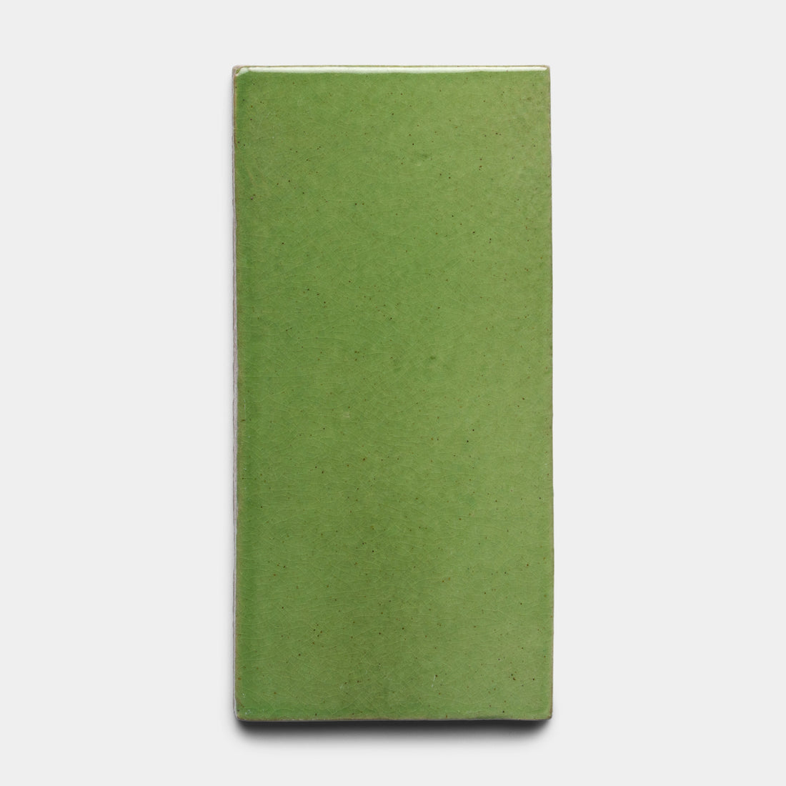 The Primavera 4x8 Rectangle tile by Zia Tile, a glossy green ceramic rectangle, is centered against a plain white background.