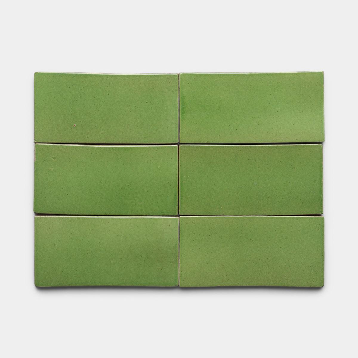 Six Zia Tile Primavera 4x8 Rectangle green ceramic tiles, with a smooth, slightly glossy finish, are arranged in two rows of three on a plain white background.