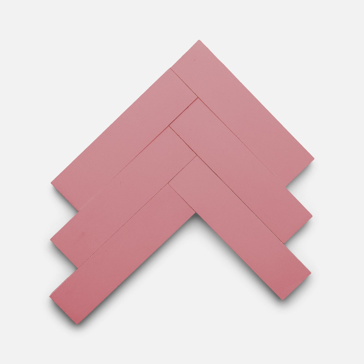 Five Protea 2x8 rectangular pink tiles by Zia Tile are arranged in a herringbone pattern on a plain white background.