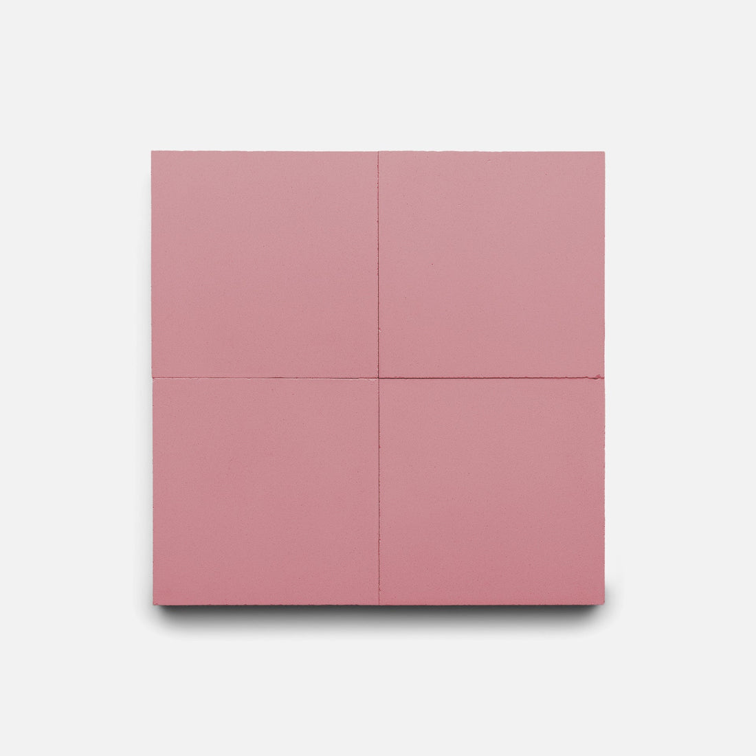 The Protea 4x4 Sample by Zia Tile is a square, solid pink handmade tile with two intersecting lines dividing it into four equal sections, displayed on a plain white background.