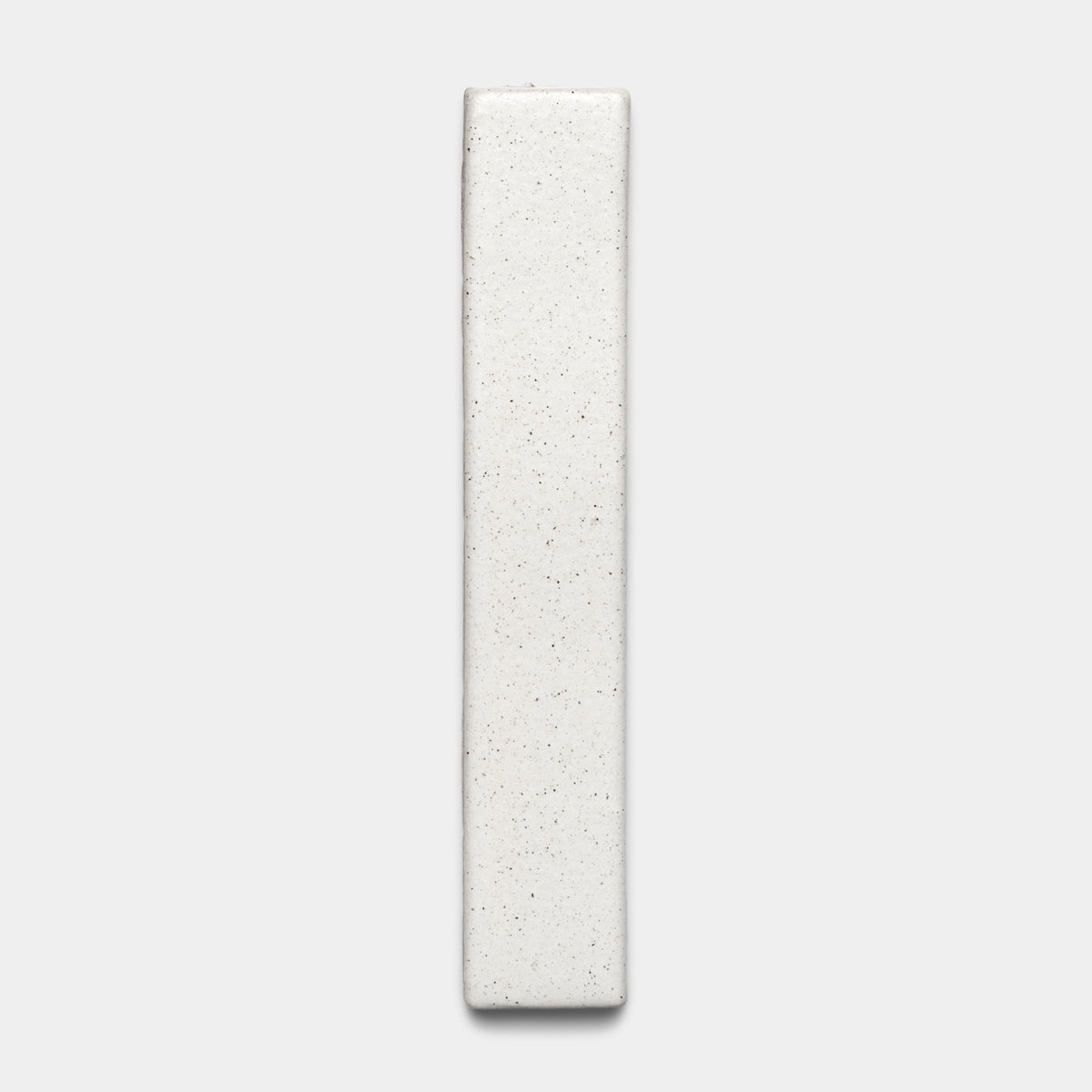 The Puebla Mini Bar by Zia Tile is a rectangular, off-white ceramic tile with a slightly textured, speckled surface, displayed vertically against a plain light gray background.