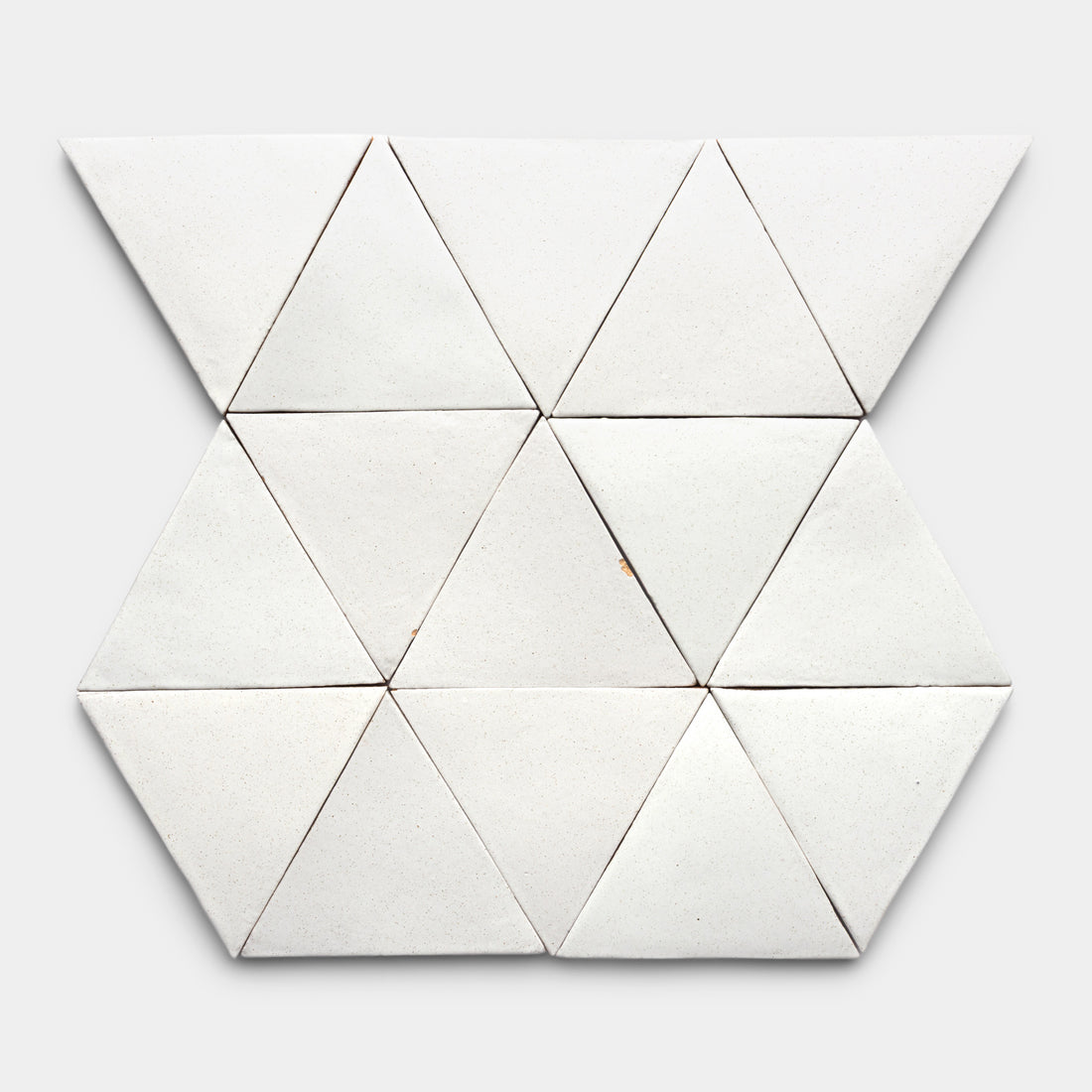 Nine Puebla Triangle tiles by Zia Tile are arranged in a geometric, hexagonal pattern with triangular shapes on a plain light gray background, emphasizing the tiles' symmetry and clean lines.
