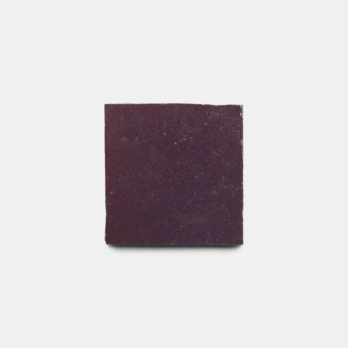 A square Purple Iris 2x2 tile sample from Zia Tile, in deep purple, is centered on a plain white background, evoking the bold color blocks characteristic of Zia Tile’s handmade cement tiles.