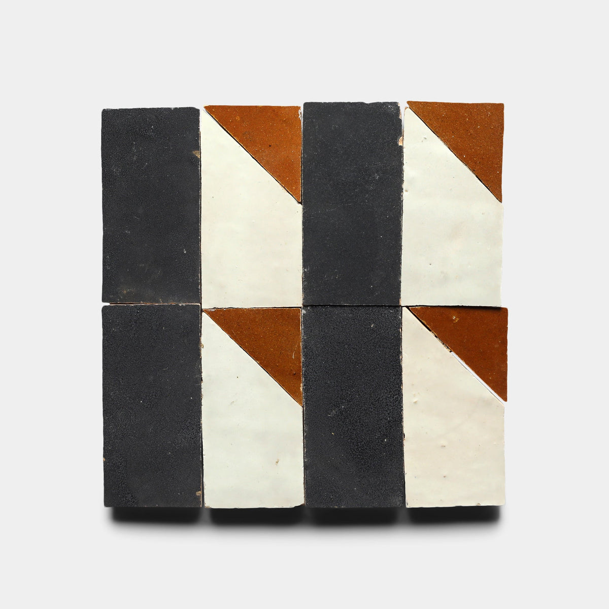Four Radian Inline 2 tiles by Zia Tile are arranged in a 2x2 grid. Each handmade tile features black, white, and brown triangles for a geometric, minimalist look on a light gray background.