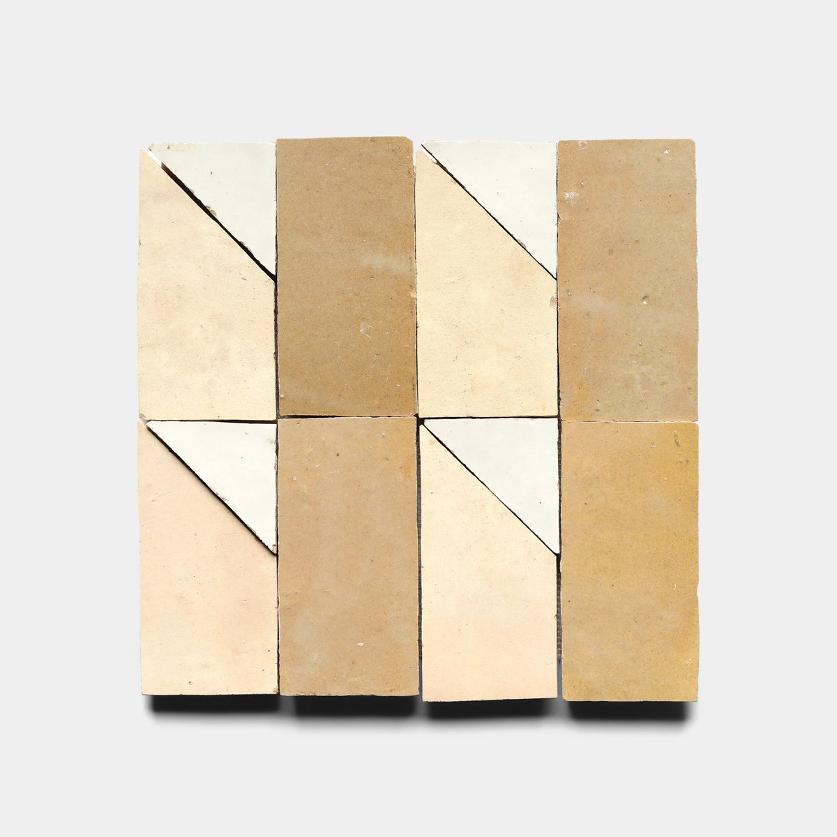 Six Radian Inline 4 samples from Zia Tile are arranged in two columns and three rows. Each rectangular tile features a diagonal divide with one half beige or tan, the other white or cream, set against a light gray background.