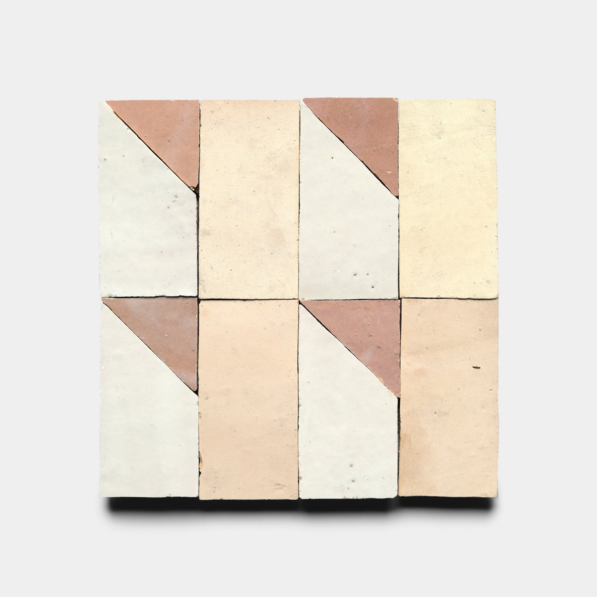 Six rectangular Zia Tile Radian Inline 5 tiles are arranged in two rows of three, each with a diagonal terracotta and light beige contrast, forming a bold geometric pattern against a plain background.