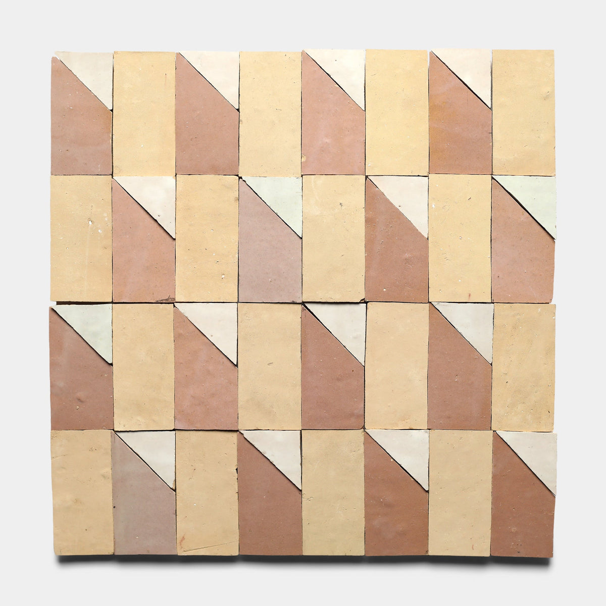 The Radian Offset 2 sample by Zia Tile features square handmade tiles in beige, tan, and off-white that form a geometric design with diagonal cuts, creating repeating triangles and parallelograms.