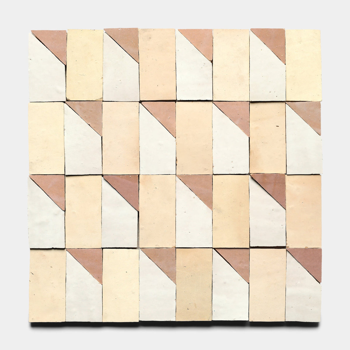 A grid of Zia Tile's Radian Offset 5 samples in beige, tan, and off-white, each square divided diagonally into two contrasting triangles for a geometric pattern on a light gray background.