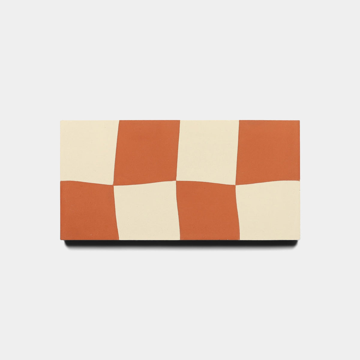 The Reality Check Rust 4x8 Sample by Zia Tile is a rectangular tile with a red and off-white checkerboard pattern and gently wavy edges, displayed on a plain white background.