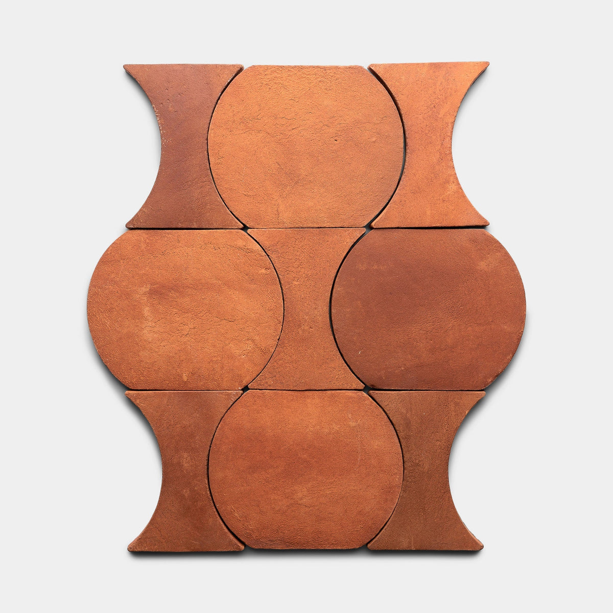 Six Oaxaca + Red Clay tiles by Zia Tile are interlocked in a geometric pattern, forming circular and hourglass-shaped spaces on a light gray background.