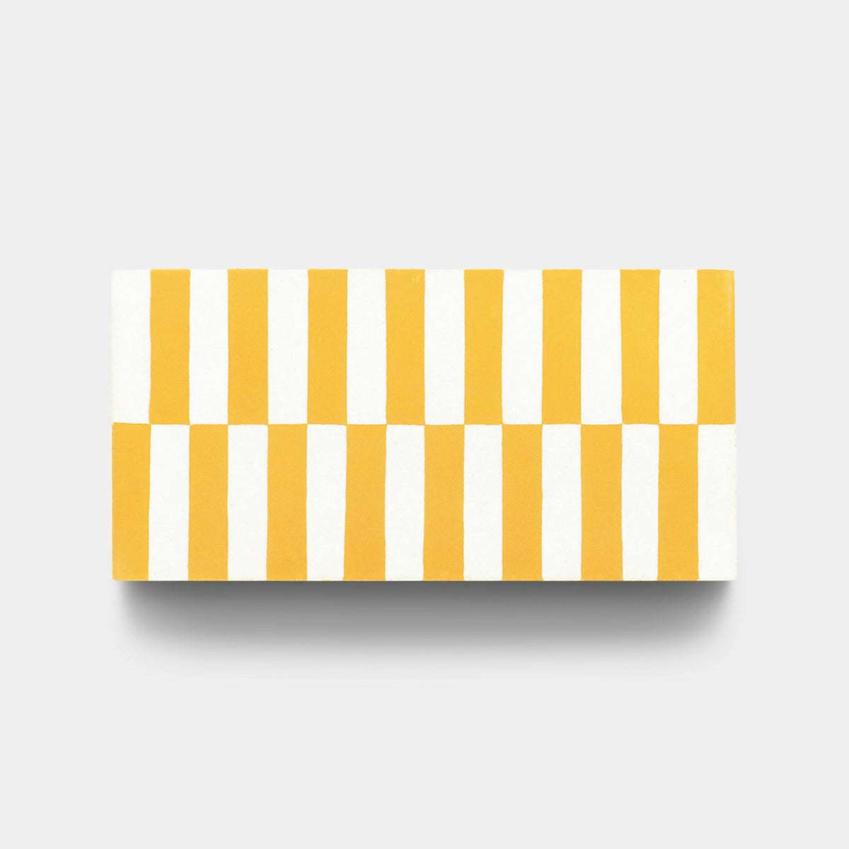 The Rialto Cadmium 4x8 tile sample by Zia Tile is a handmade rectangular tile featuring alternating vertical yellow and white stripes, arranged in two horizontal rows on a light gray background.