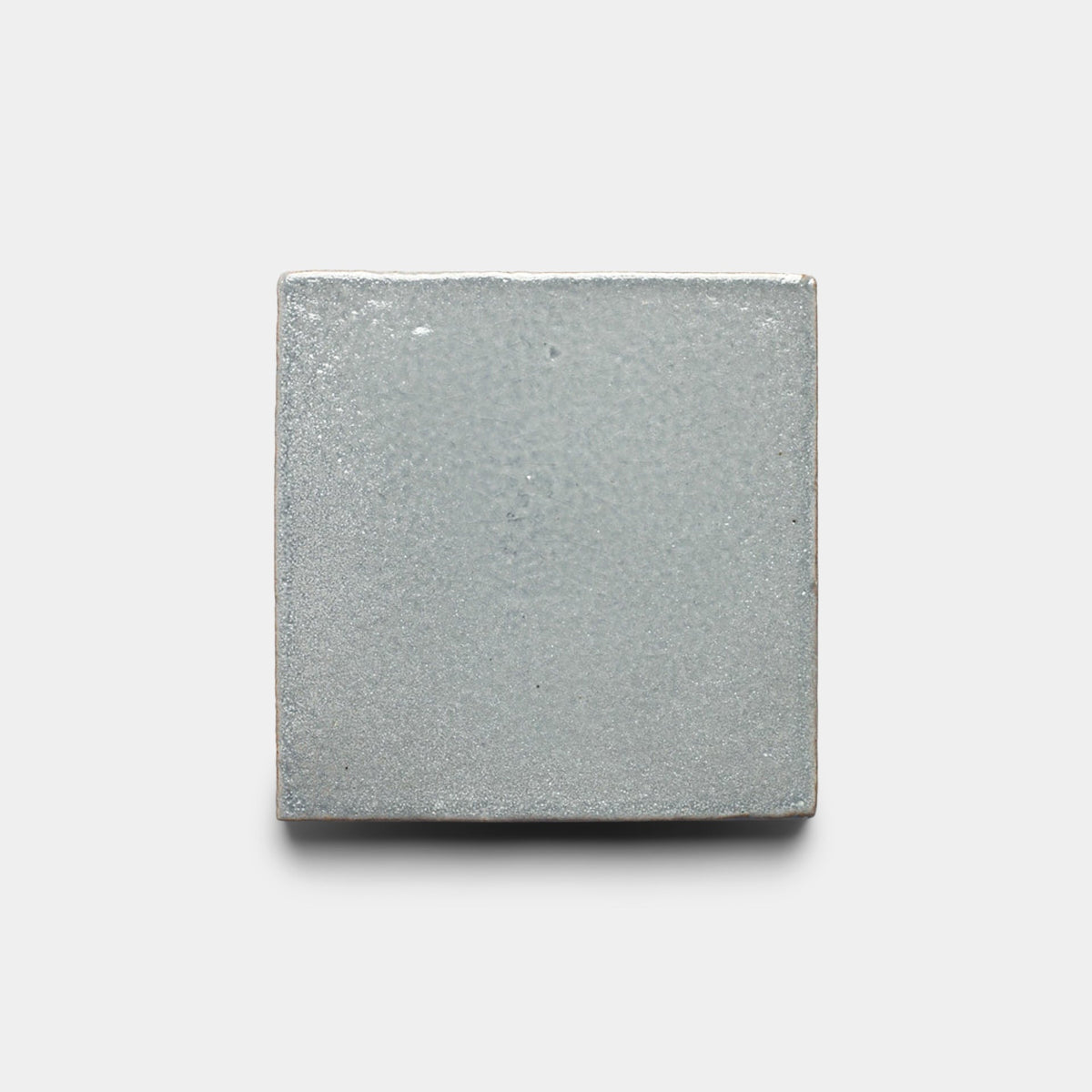 The Roca 4x4 Square, Sample by Zia Tile is a light gray ceramic tile with a smooth matte finish, shown against a plain white background.