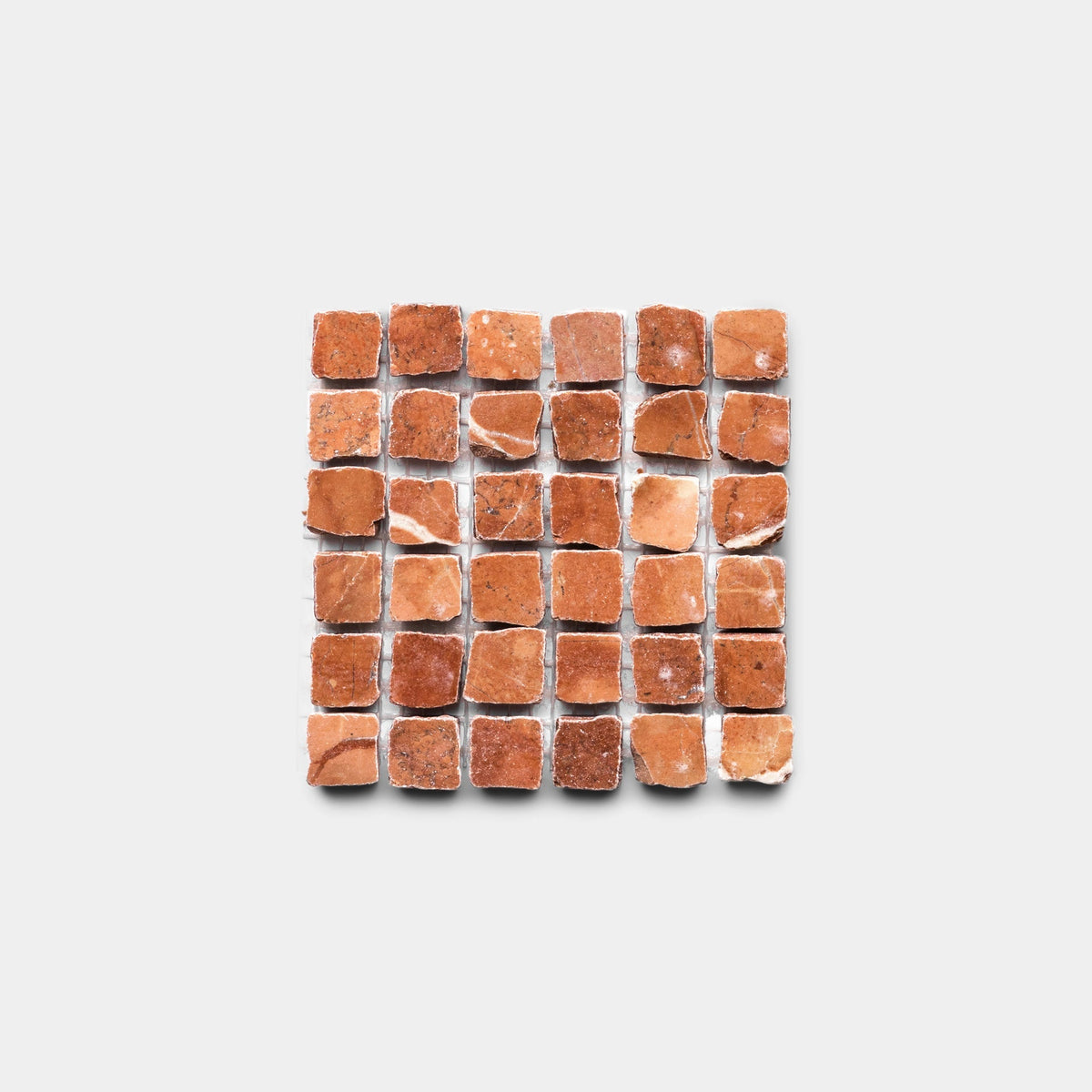 A sample of Zia Tile's Ventaglio in Rosso Alicante: small, rustic, reddish-brown stone tiles with irregular surfaces arranged in a square grid on a plain white background.