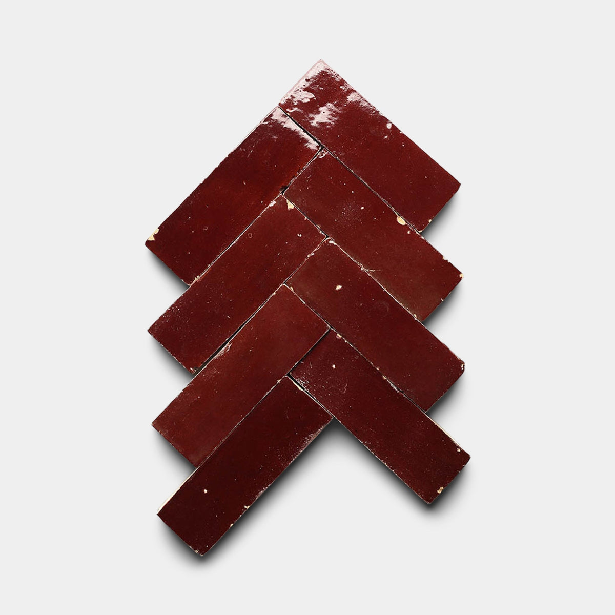 Seven glossy, rectangular Rouge 2x6 samples from Zia Tile are arranged in a herringbone pattern on a plain white background.