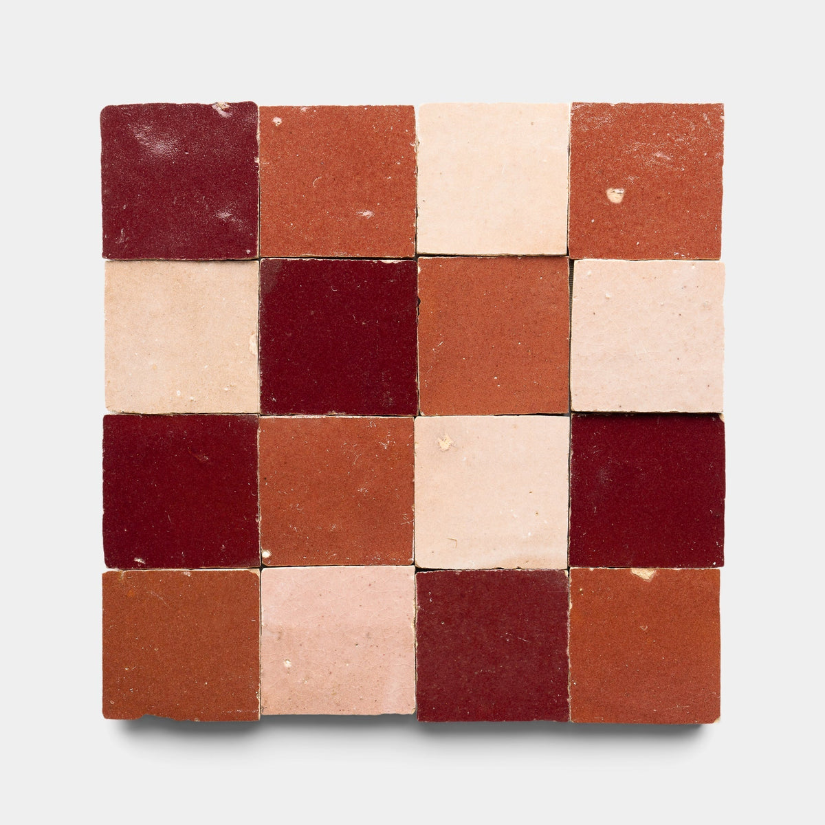 The Rouge + Terra Rosa + Desert Bloom Checkerboard Sample by Zia Tile features sixteen handmade tiles in red, orange, and beige arranged in a square checkerboard pattern on a light gray background.