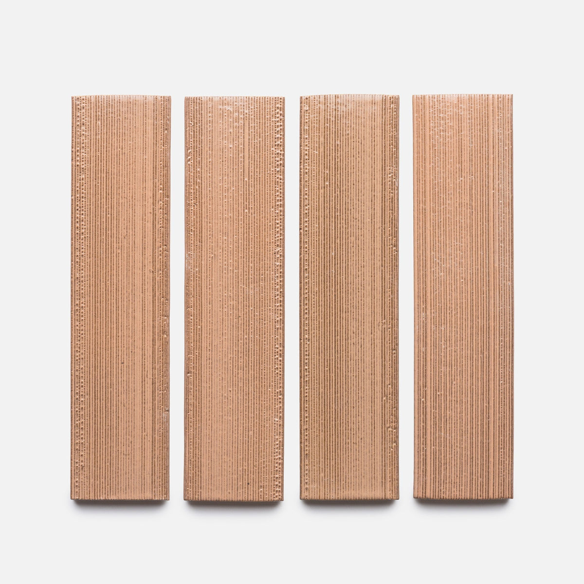 Four upright rectangular Sakura + Etched, Sample tiles by Zia Tile, featuring vertical ridges, are arranged in a row on a plain light background.