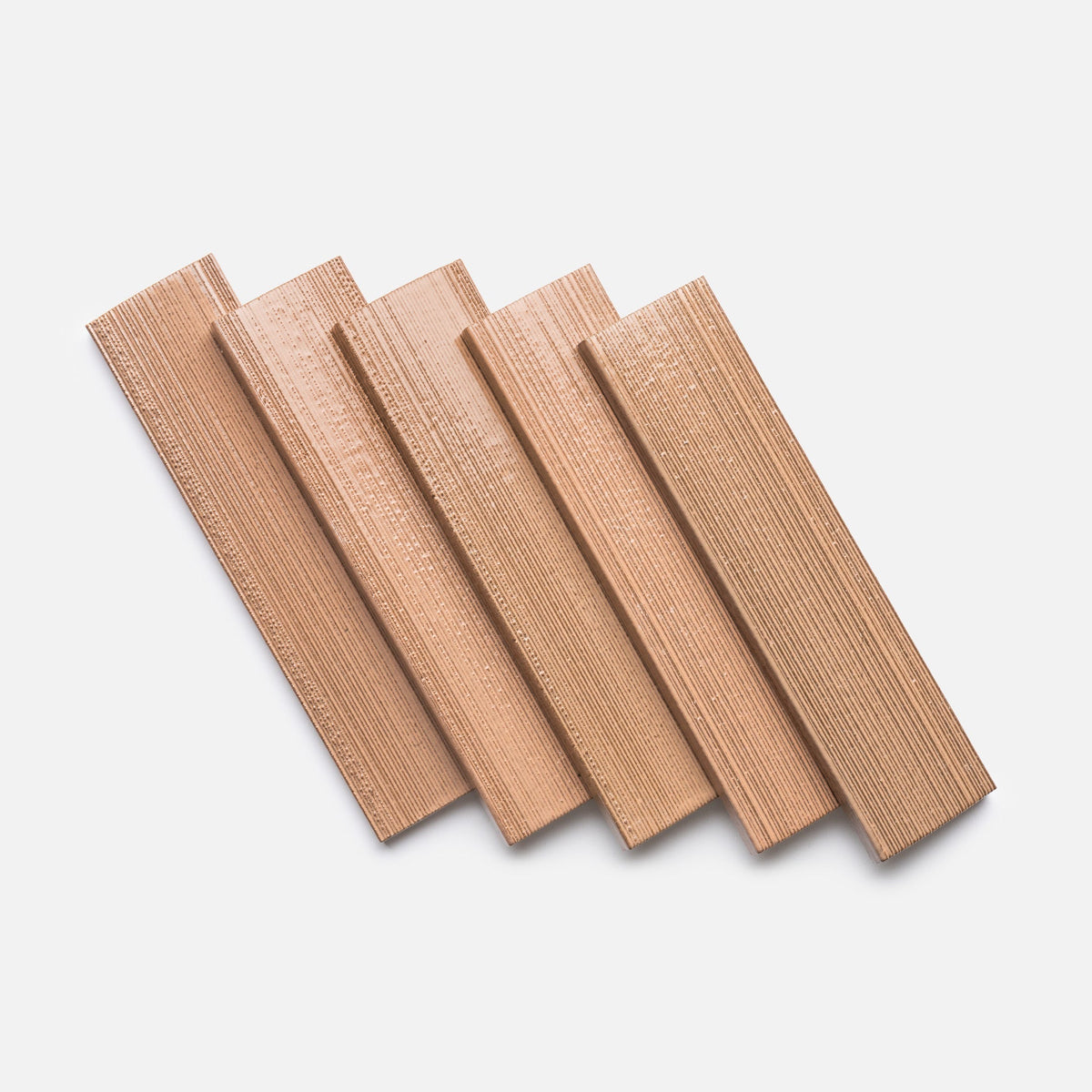 Five Sakura + Etched wood sample planks from Zia Tile, featuring visible grain patterns, are arranged diagonally and overlapping on a white background.