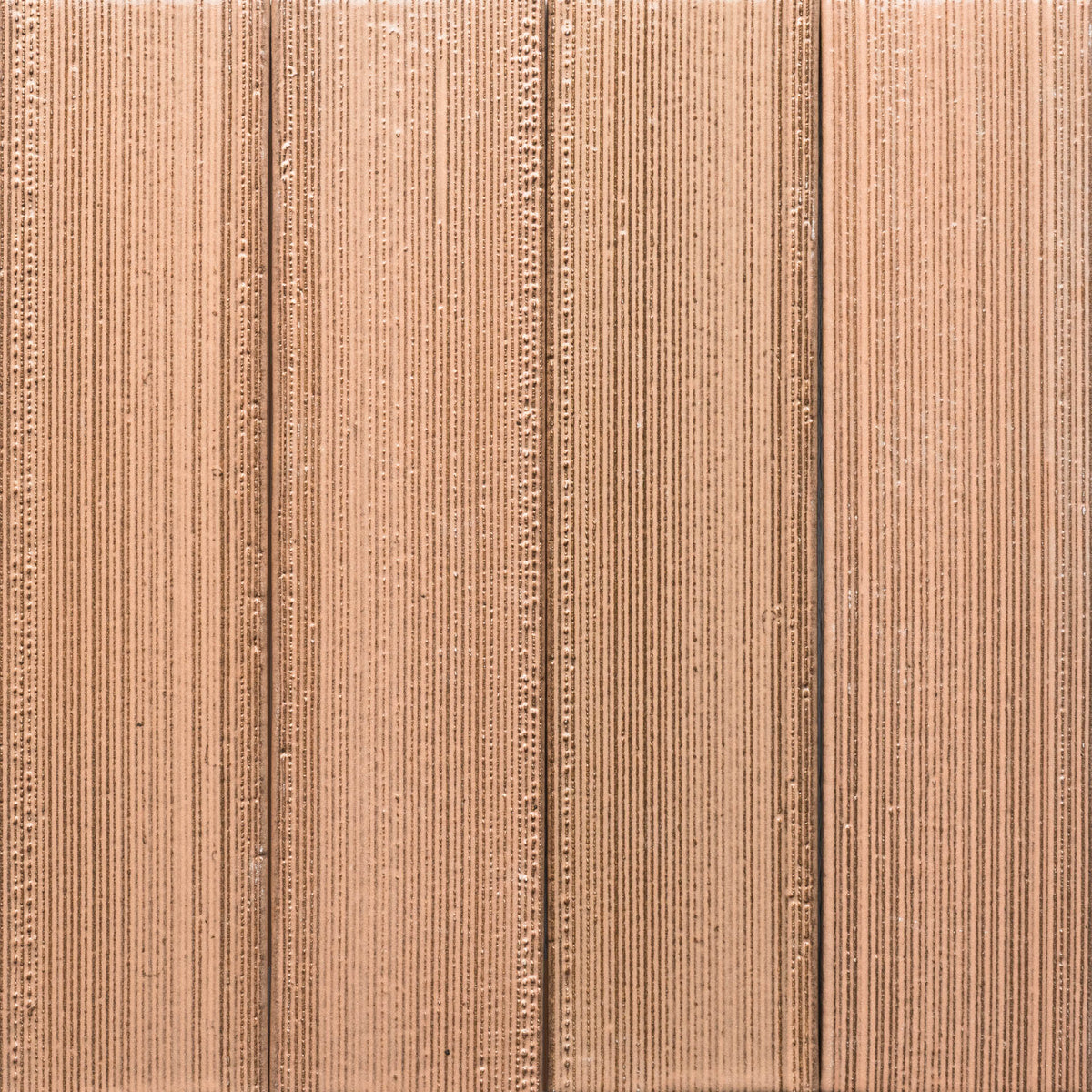 An aerial view shows the Sakura + Etched, Sample tile by Zia Tile, featuring a large, flat surface with parallel rows and furrows in light brown tones that create striking vertical line patterns.