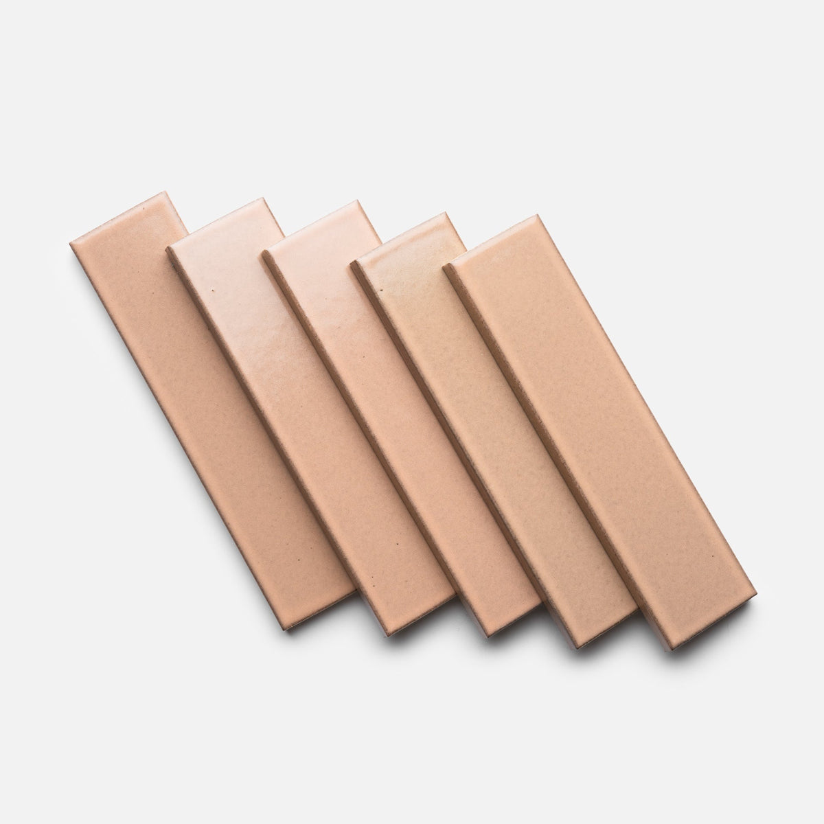 Five Sakura + Flat, Sample tiles by Zia Tile, rectangular and glossy in light brown, are arranged side by side in a staggered, overlapping pattern on a white background.