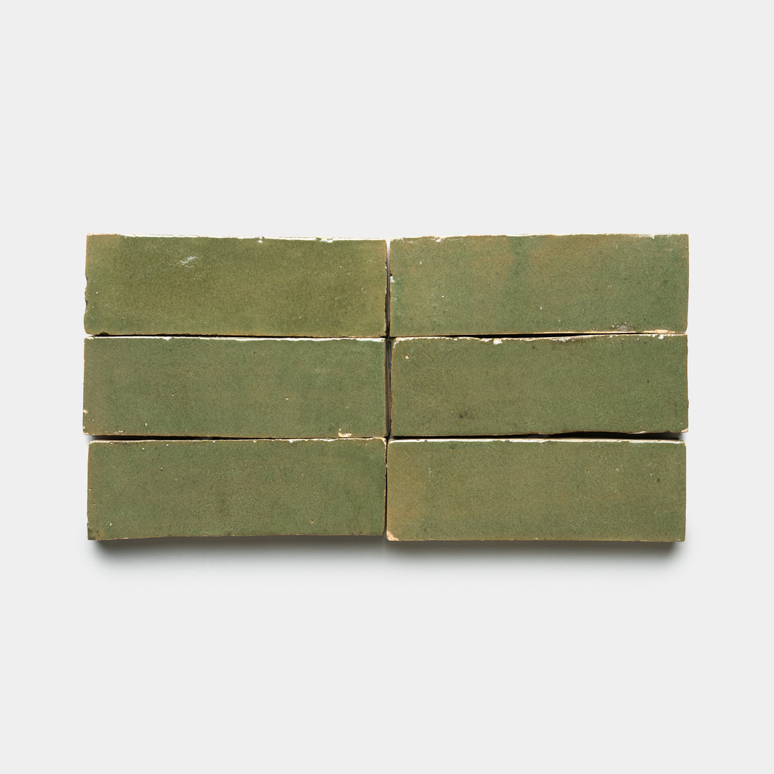 Six Savanna 2x6 tiles by Zia Tile, rectangular and green with a matte, handmade look and slightly uneven edges, are arranged in two rows of three on a plain white background.