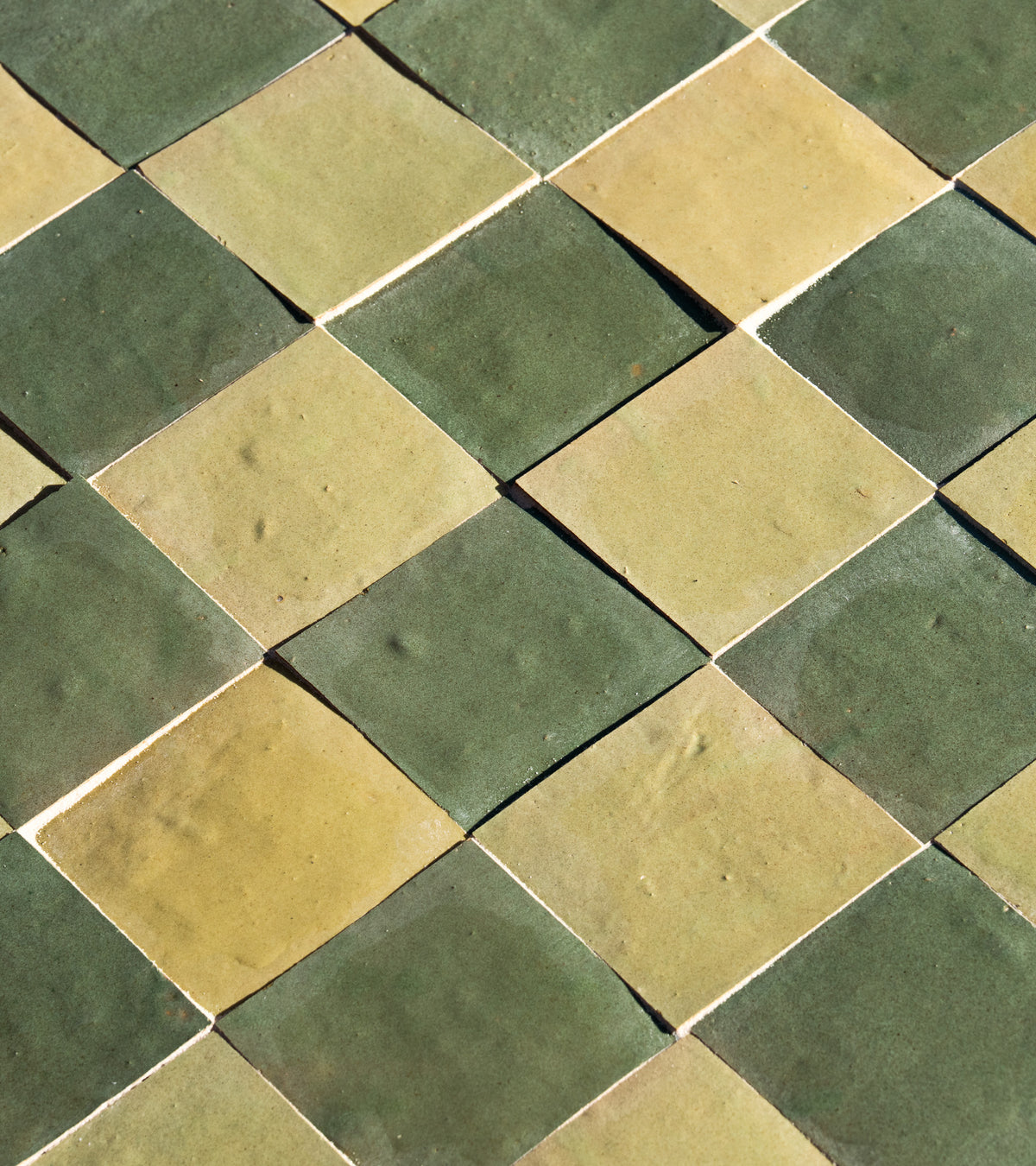 A close-up of Za'atar 4x4 tiles by Zia Tile shows alternating green and beige diamond-shaped tiles in a diagonal checkerboard pattern.