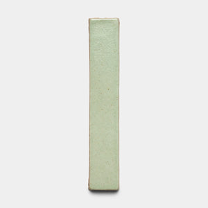 The Sayulita Mini Bar by Zia Tile stands vertically against a plain white background, featuring a smooth, pale green glazed ceramic surface with slightly textured edges.