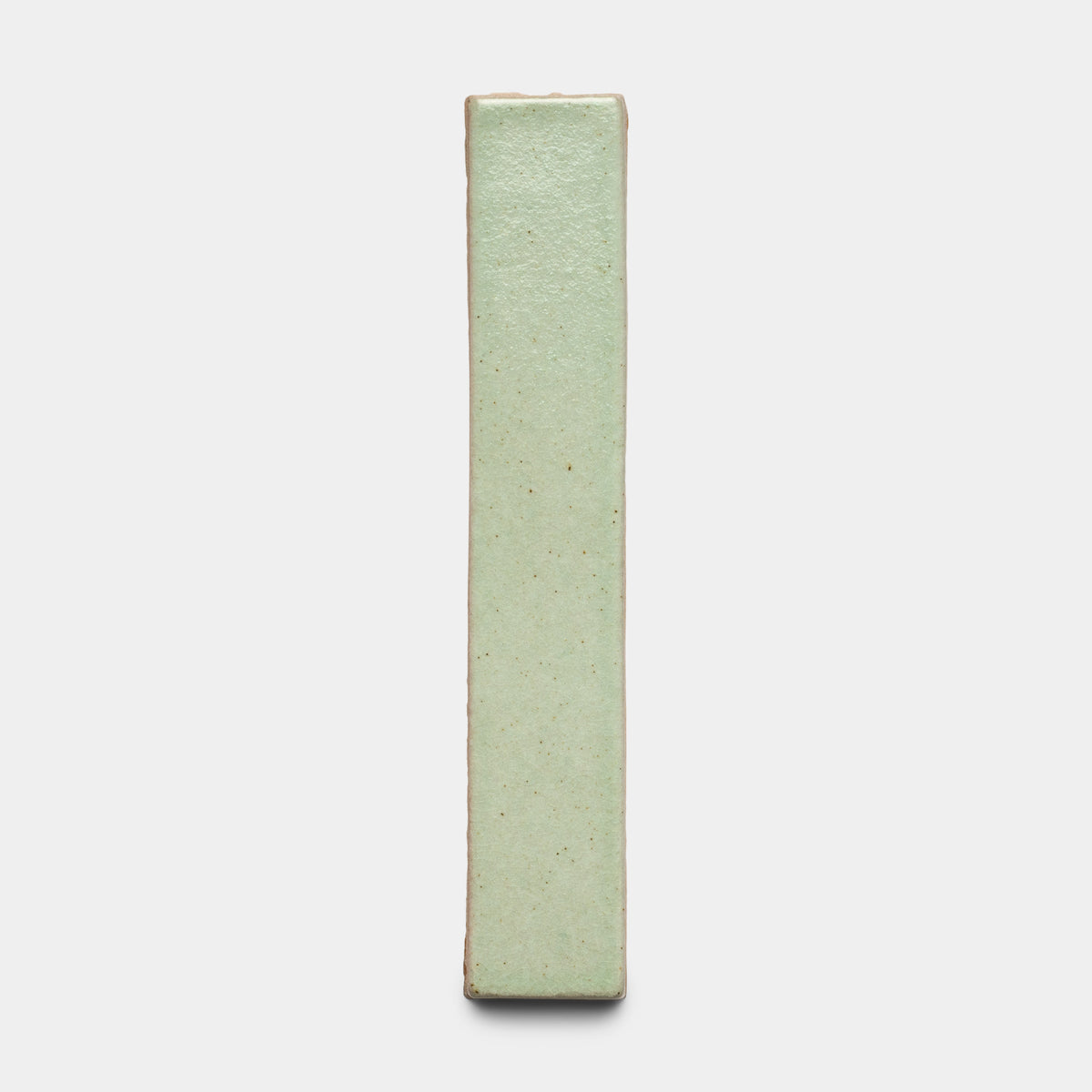 The Sayulita Mini Bar by Zia Tile stands vertically against a plain white background, featuring a smooth, pale green glazed ceramic surface with slightly textured edges.