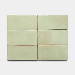 Six Sayulita 4x8 Rectangle tiles by Zia Tile, in pale green ceramic with a smooth matte finish and slightly uneven edges, are arranged in two rows of three on a light gray background.