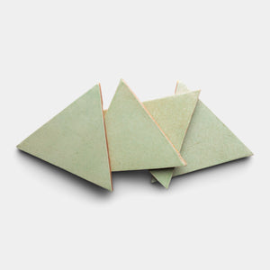 Four Sayulita Triangle tiles by Zia Tile, each an equilateral ceramic piece in pale green, are arranged in an overlapping pattern on a plain white background.