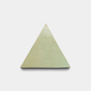 The Sayulita Triangle by Zia Tile is an equilateral, light green tile with a smooth finish, centered on a plain white background and casting a soft shadow below.