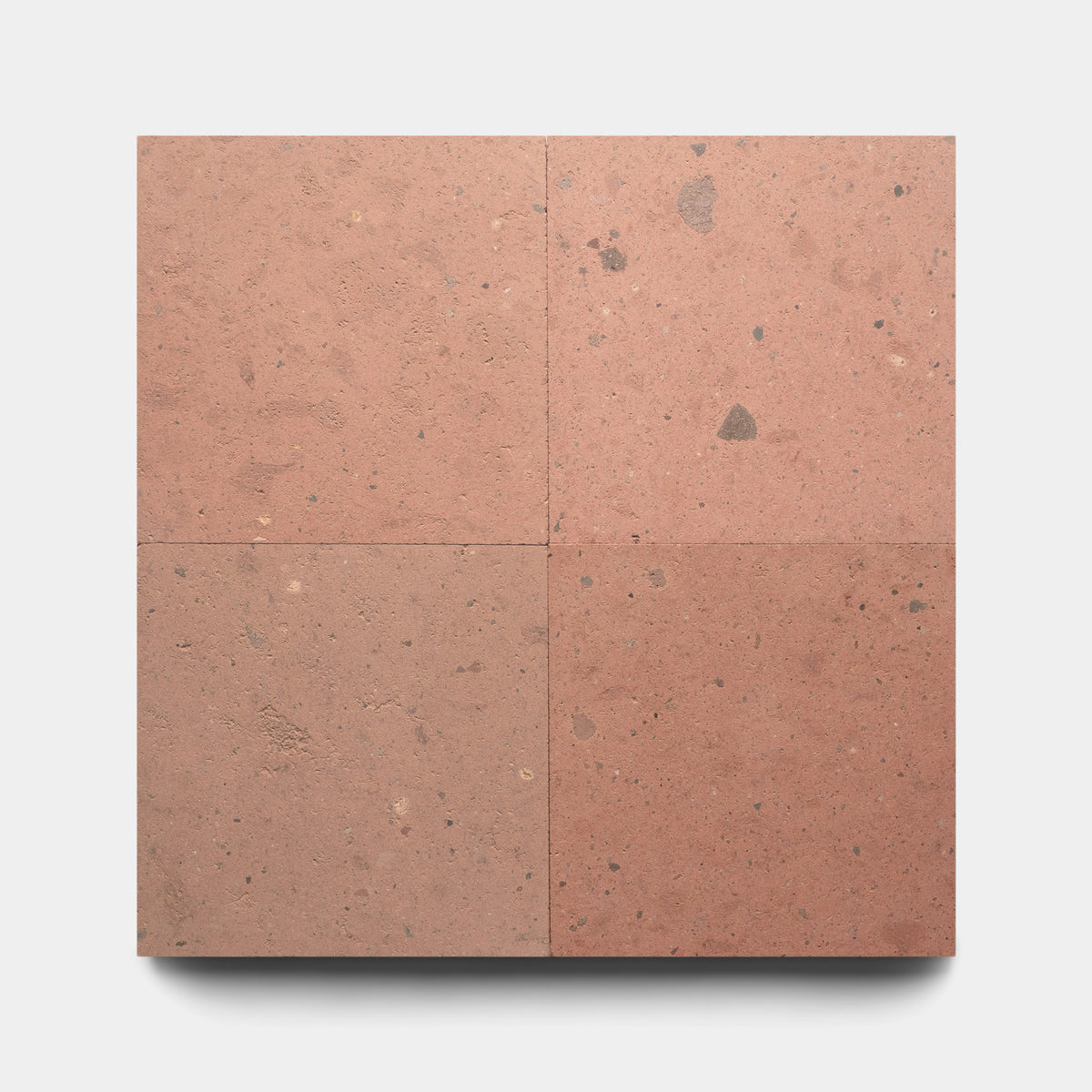 Four Sedona 12x12 tiles by Zia Tile are arranged in a grid on a white background, showcasing their natural reddish-brown volcanic stone look with subtle speckles, imperfections, and color variations.