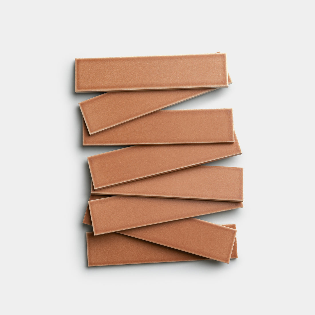 Eight Sepia 2x8 Zia Tile rectangles are stacked in a staggered, zigzag pattern on a white background.