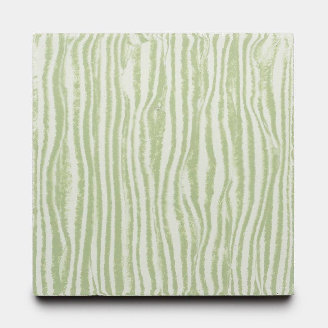 The Shoreline Saguaro + Julep 8x8 tile by Zia Tile features light green and white wavy vertical stripes, resembling abstract wood grain or zebra stripes, on a square tile set against a plain white background.