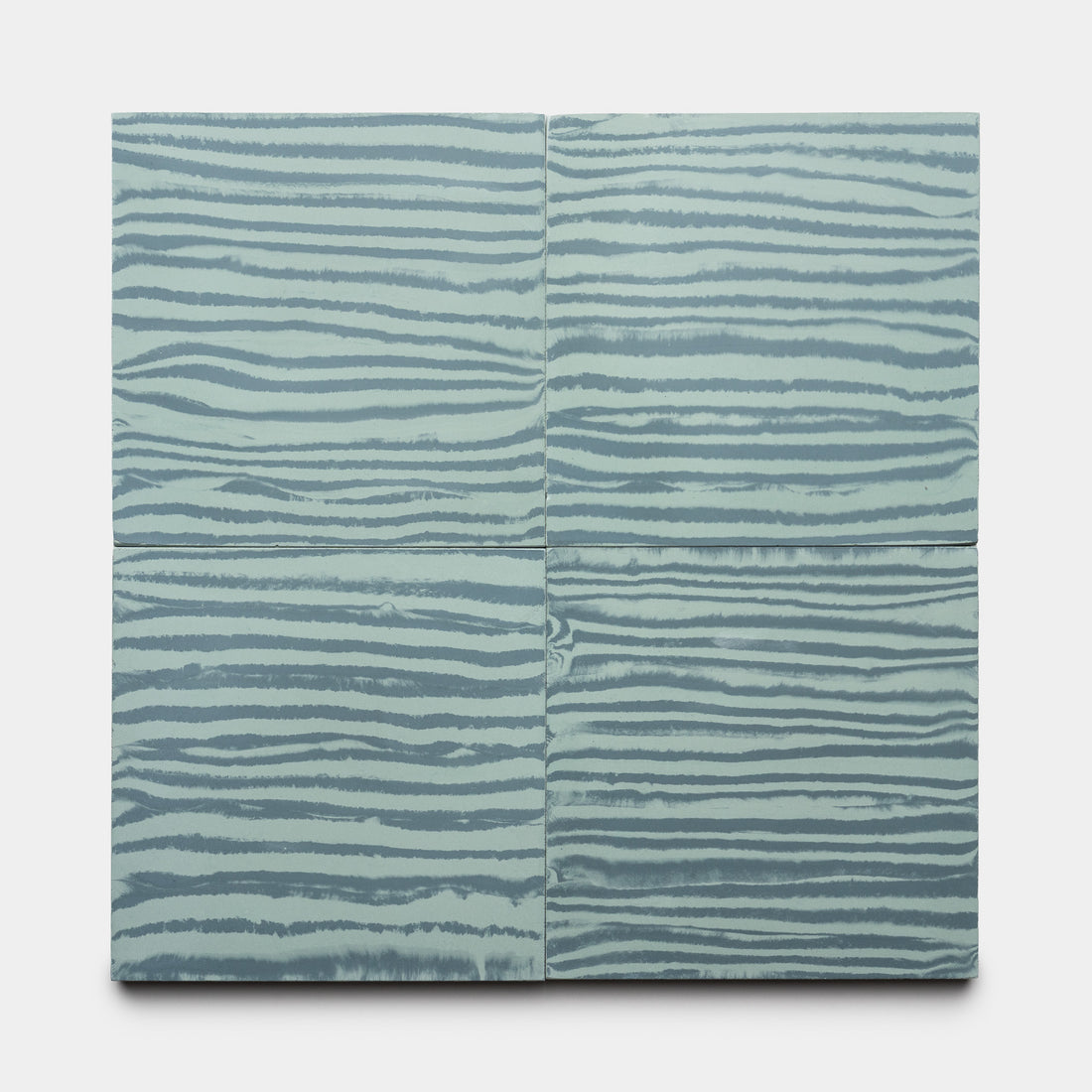 Four Shoreline Slate + Sage 8x8 tiles by Zia Tile, featuring horizontal wavy stripes in light blue and gray tones, are arranged in a grid on a white background.