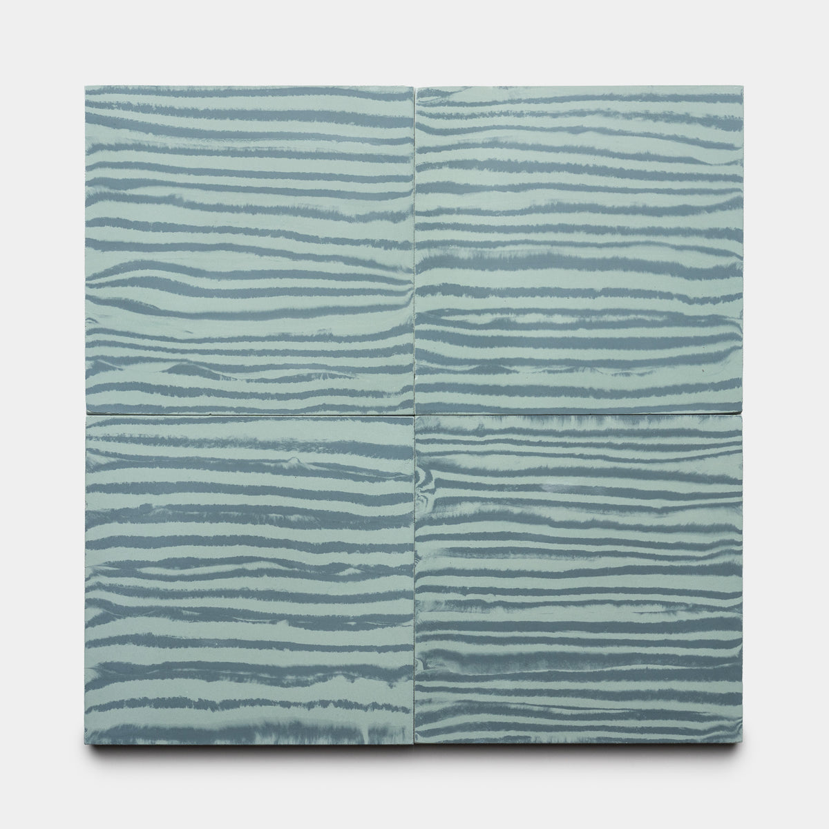 Four Shoreline Slate + Sage 8x8 tiles by Zia Tile, featuring horizontal wavy stripes in light blue and gray tones, are arranged in a grid on a white background.